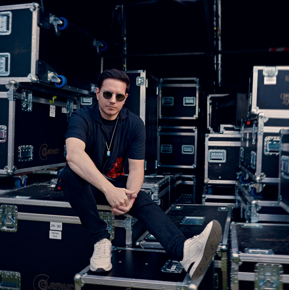 Thomas Sykes backstage surrounded by flight cases